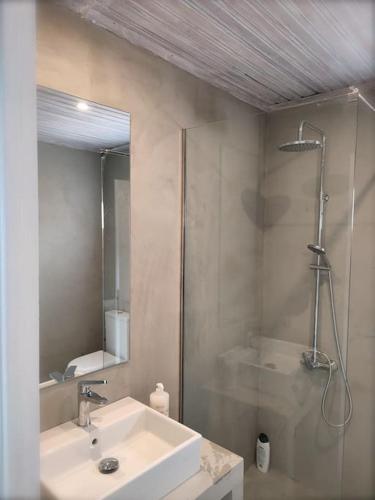a bathroom with a white sink and a shower at Lilly's Seaview Retreat Cottage in Avlákia