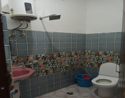 a bathroom with a toilet and a pink sink at Hotel Deep Kishan by StayApart in Trijugi Nārāyan