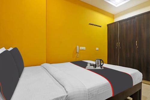 a bedroom with a bed and a yellow wall at Super Collection O Vinayaka Gachibowli in Kondapur