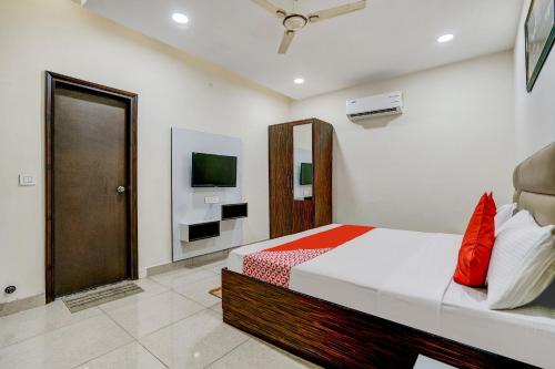 1 dormitorio con 1 cama y TV en la pared en Super OYO Hotel 7 Sky, en Ludhiana
