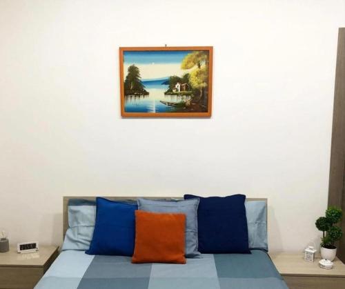 1 cama con almohadas azules y naranjas en una habitación en B&B Nonno Walter, en Torre del Greco
