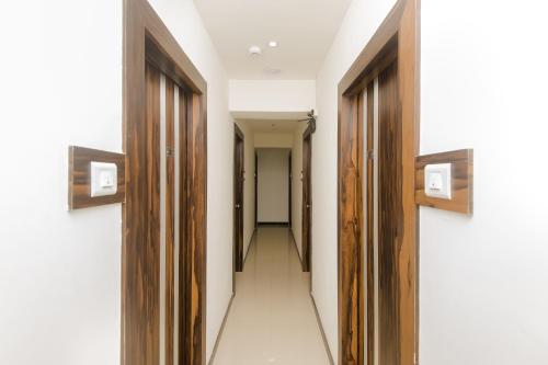 a corridor with wooden doors and a hallway with at Hotel O Gems in Turambhe