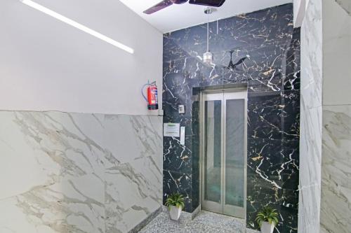 a bathroom with a black and white marble wall at Super Hotel O Rishabh Inn in Ghaziabad