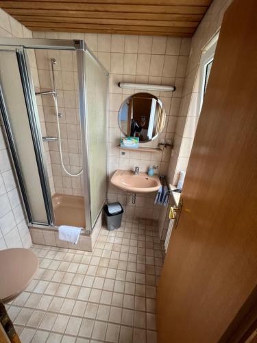 a bathroom with a sink and a shower and a mirror at Pension Seliger in Meersburg