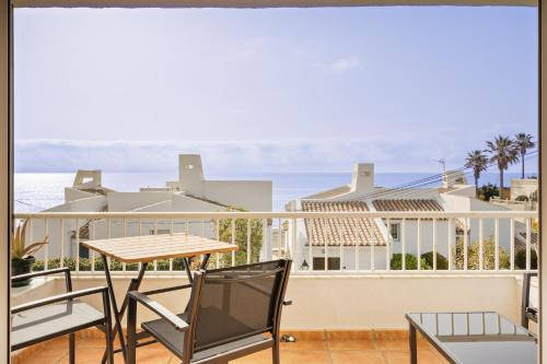 balcón con mesa, sillas y vistas al océano en Sunny Beach Apartment, en Estepona