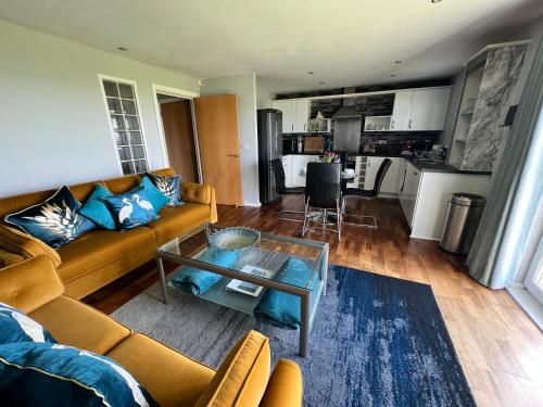拉內利的住宿－CockleDora, A Luxury Ground Floor Beachfront Apartment，客厅配有沙发和桌子