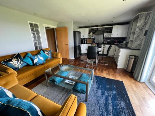 a living room with a couch and a table at CockleDora, A Luxury Ground Floor Beachfront Apartment in Llanelli