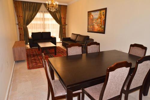 a dining room with a table and chairs and a couch at Hanno Residence in Soûr