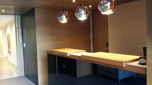 ein Badezimmer mit einer Holztheke und Hängelampen in der Unterkunft Sereine Sukhumvit 39 in Bangkok