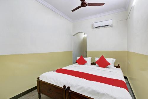 1 dormitorio con 1 cama grande con almohadas rojas en OYO Suraj Residency, en Warangal