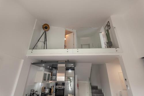 um quarto com paredes brancas e uma escada com um espelho em Casa Alegria Barra Deluxe by Home Sweet Home Aveiro em Gafanha da Nazaré