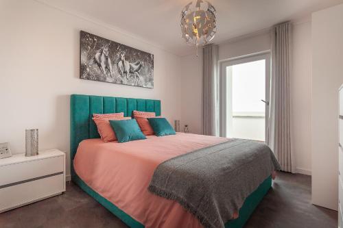 a bedroom with a large bed with a green headboard at Casa Alegria Barra Deluxe by Home Sweet Home Aveiro in Gafanha da Nazaré