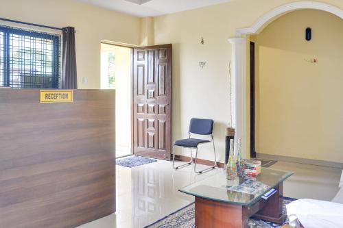 a room with a door and a chair and a table at OYO Infinity Inn in Dhantoli