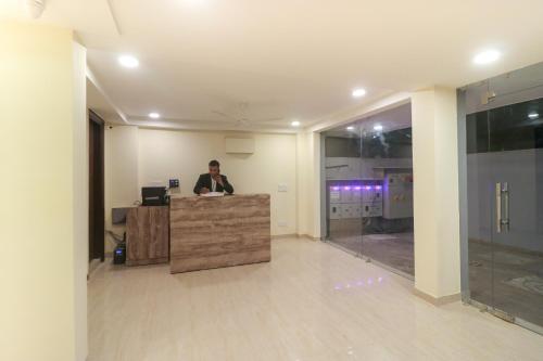 un hombre de pie en un escritorio en una oficina en Super OYO Flagship Comfort Residency Near Artemis Hospital, en Gurgaon