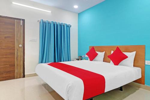 a bedroom with a large bed with red pillows at Hotel O Langar Houz Near Golconda Fort in Hyderabad