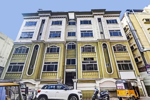 una macchina bianca parcheggiata di fronte a un edificio di Capital O Hotel Samrat Palace Near Nampally Station a Hyderabad