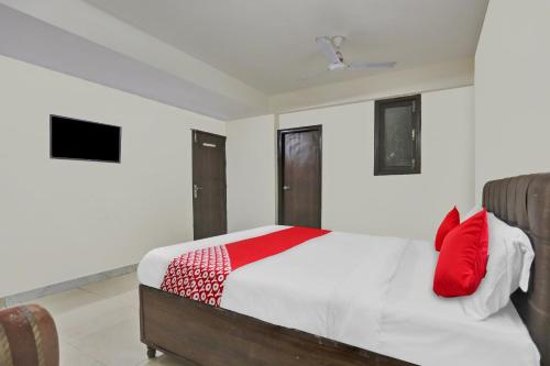 a bedroom with a bed with red pillows on it at Flagship Raj Pavilion Near Lotus Temple in New Delhi