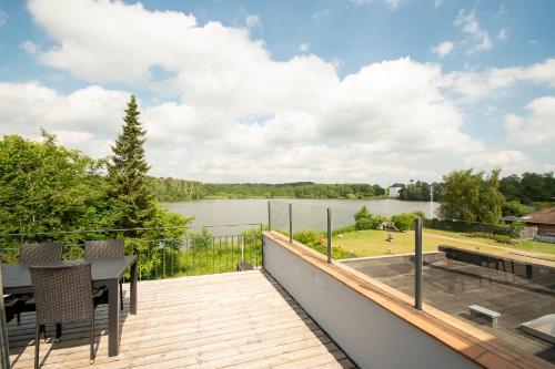 a deck with a table and chairs and a view of a lake at Det Gamle Rådhus in Gråsten