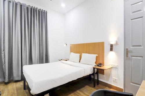 a hotel room with a bed and a desk and a window at OYO Townhouse 78364 Townhouse 388 Madhapur Near Shilparamam in Kondapur