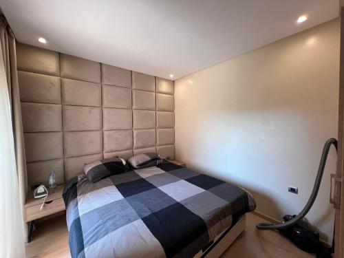Appartement de luxe a Marrakech في مراكش: غرفة نوم بسرير وبطانية بيضاء وسوداء