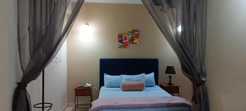 a bedroom with a bed with a blue head board at Hotel Catedral in Ciudad del Este