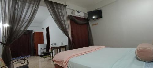 a bedroom with a bed with a pink blanket at Hotel Catedral in Ciudad del Este