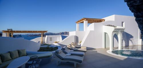 a patio with chairs and a swimming pool at Acro Blue Luxury Villas in Akrotiri