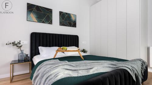 a bedroom with a bed with a wooden table on it at Flatbook - City Center Apartments Granaria in Gdańsk