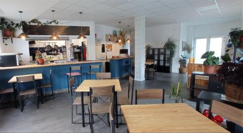 un restaurant avec des tables et des chaises et une cuisine dans l'établissement AlbergueMyway, à Astorga