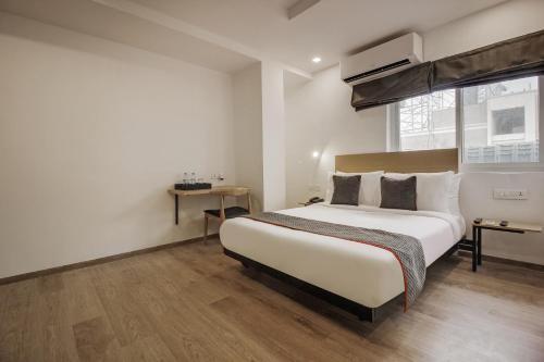 a bedroom with a large bed and a window at Townhouse Begumpet Near Hyderabad Central in Ameerpet