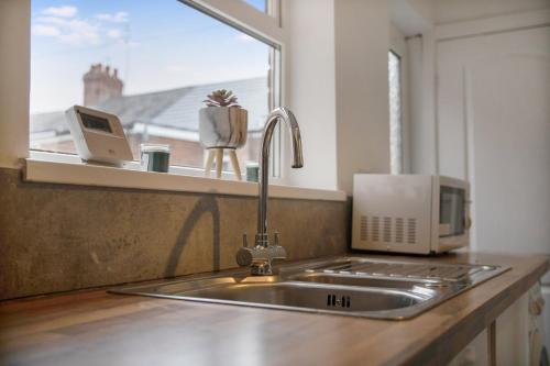 a kitchen sink with a microwave and a window at Freshly Renovated, Feels Like Home, Sleeps 3 in Chester-le-Street