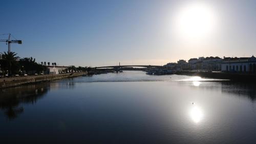 a view of a river with a bridge in the background at Casa do Almirante in Tavira