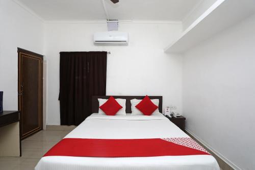 a bedroom with a bed with red pillows at Hotel O Jalan Lake View Near Mani Square in Tangra