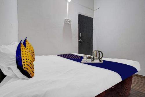 SPOT ON Friends Service Appartment في ناغبور: سرير عليه وسادة صفراء وزرقاء