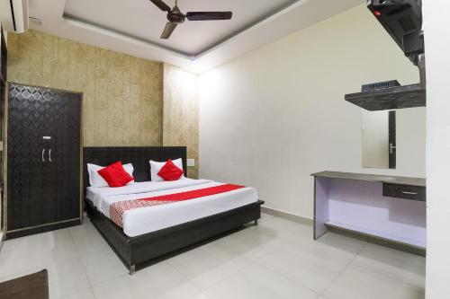 a bedroom with a bed with red pillows at OYO Hotel Samrat in Kānpur