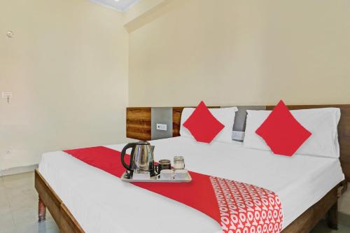 a bed with red and white pillows and a table at OYO Star Residency Near Omaxe Gurgaon Mall in Gurgaon