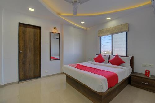 a bedroom with a large bed with red pillows at RK regency in Yerandwane