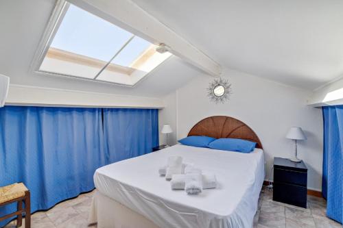 une chambre avec un grand lit avec des rideaux bleus dans l'établissement Duplex Cigarra - Welkeys, à Bandol