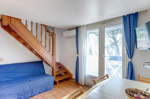 - un salon avec un canapé bleu et un escalier dans l'établissement Duplex Cigarra - Welkeys, à Bandol