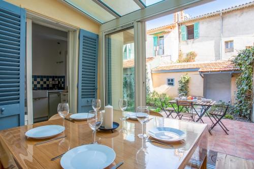 uma sala de jantar com uma mesa com copos de vinho em Maison Castel - Welkeys em Toulon