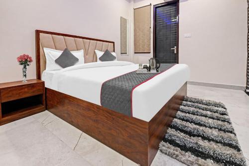 een slaapkamer met een groot bed met een houten hoofdeinde bij Townhouse Kalyanpur Metro in Kaliānpur