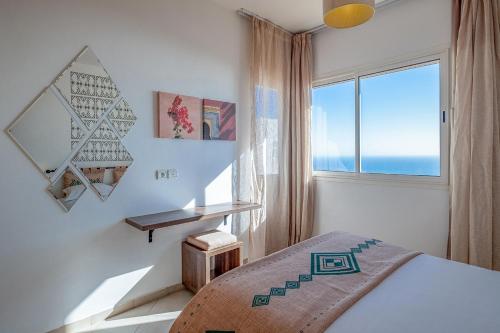 um quarto com uma cama e uma grande janela em Lunja Village - Agadir em Taghazout