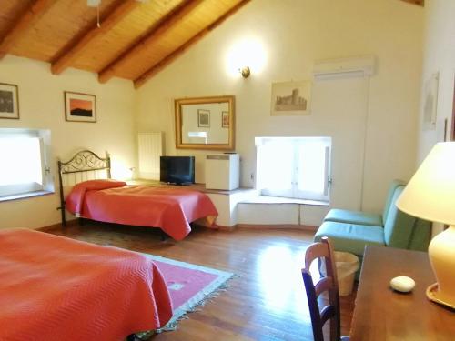 ein Schlafzimmer mit einem Bett, einem Sofa und einem TV in der Unterkunft Case Zuccaro in Trecastagni