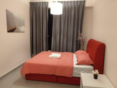 een slaapkamer met een bed met oranje lakens en een raam bij KA1707 - Cyberjaya-Netflix-Wifi- Parking, 1005 in Cyberjaya