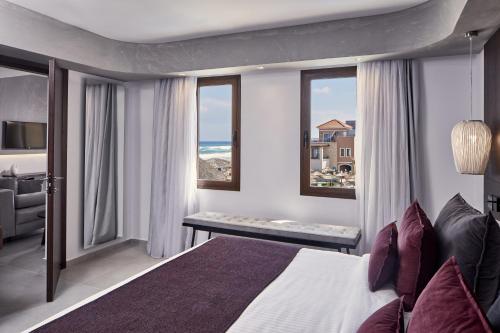 a bedroom with a bed and a view of the ocean at Atlantica Caldera Palace in Hersonissos