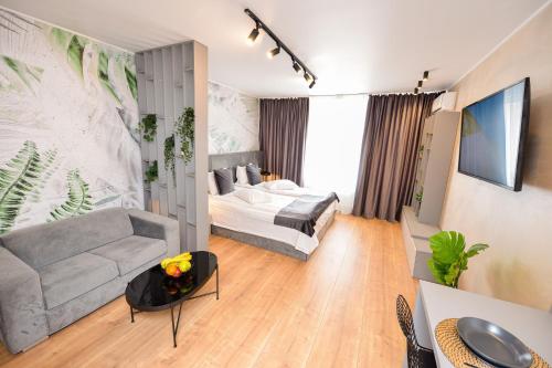 ein Wohnzimmer mit einem Bett und einem Sofa in der Unterkunft One by One - by Grand Accommodation in Bukarest