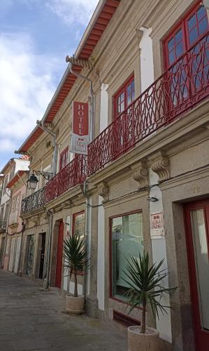 a building with two palm trees in front of it at Rua Grande Hotel in Viana do Castelo