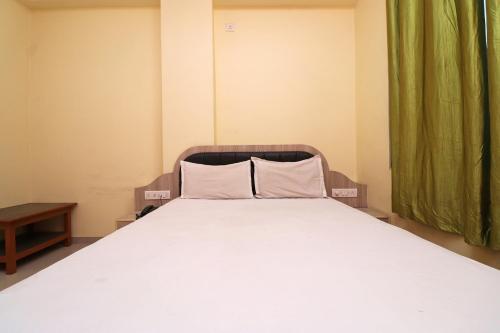 a bed with two pillows on it in a room at SPOT ON Hotel Midtown in Darbhanga