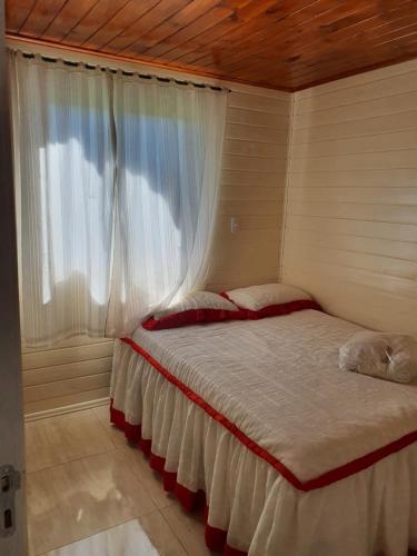 a bed in a room with a window at Casa p fim de semana in Urupema