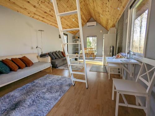 a living room with a loft bed and a kitchen at Dyreborg Boutique Guesthouse in Knäred